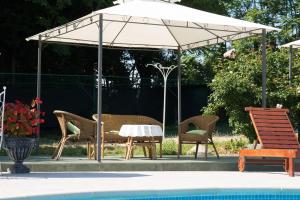 uma mesa e cadeiras debaixo de um guarda-sol ao lado de uma piscina em Villa Anna em Savudrija
