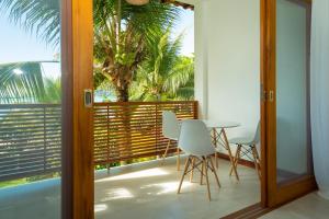d'un balcon avec une table, des chaises et un palmier. dans l'établissement Pousada Catarina, à Parati