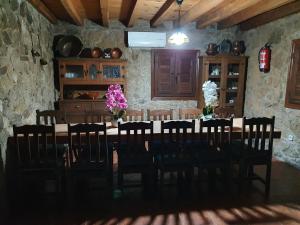 a dining room with a table with chairs and flowers at Casa Calañas in El Raso