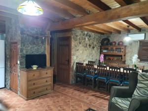 a dining room with a table and chairs and a television at Casa Calañas in El Raso