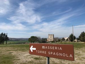 
a sign on a pole in a grassy field at Masseria Torre Spagnola in Matera
