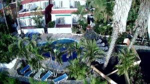 uma vista aérea de um resort com uma piscina e palmeiras em Apartamentos colon y bungalows em Los Quemados