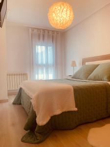 Un dormitorio con una cama grande y una lámpara de araña. en Apartamento Rio San Isidro 1, en Felechosa