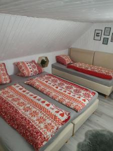 a room with two beds with red and white blankets at Adel Cottage-SAUNA-HOT TUBE in Kovářská