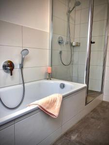 uma casa de banho com um chuveiro e uma banheira em Landhaus Via Decia - Bad Hindelang PLUS Partner em Bad Hindelang