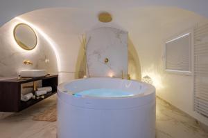 a white bathroom with a tub in a room at La Bella Ostuni Suites in Ostuni