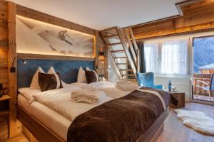 a bedroom with a large bed and a ladder at Silvana Mountain Hotel in Zermatt