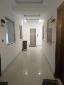 pusty korytarz z białymi ścianami i drzwiami w obiekcie New & elegant 1BR Flat for Families,tourists,4k Netflix,wifi,E11 Markaz w mieście Islamabad