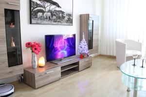una sala de estar con TV en un centro de entretenimiento de madera en Apartment with balcony, Humenné SK, en Humenné
