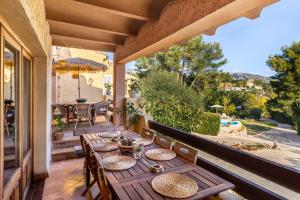 un patio con tavolo e sedie sul balcone. di Lovehaus Terra Rotja a Esporles