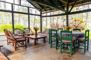 a conservatory with a table and chairs on a patio at Villa Pajon Eco Lodge in Constanza