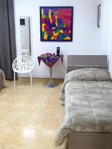 a bedroom with a bed and a table and a chair at B&B HERCULANEUM RUINS in Ercolano