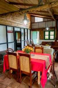 a dining room with a red table and chairs at Villa Pajon Eco Lodge in Constanza +225 photos