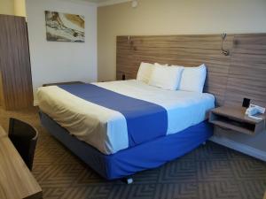 um quarto de hotel com uma cama grande num quarto em Exchange Club Motel em Beatty