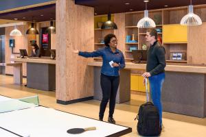a man and a woman with a suitcase in a lobby at ibis Sao Paulo Tatuape in Sao Paulo