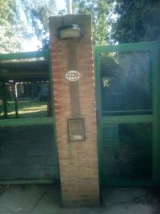 a brick pillar with a sign on it next to a gate at Dormi en Mar del Plata! in Mar del Plata