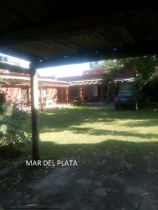 a yard with a house with a car parked in it at Dormi en Mar del Plata! in Mar del Plata