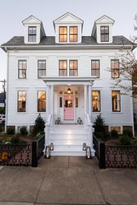 a white house with a pink door at 134 Prince - Luxury Boutique Hotel in Annapolis