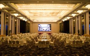 a large banquet hall with white tables and chairs at Yangzhong Firth Jinling Grand Hotel in Yangzhong +54 photos