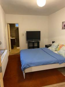 a bedroom with a bed and a flat screen tv at superbe appartement in Charleroi