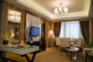 a living room with a dining table and a living room with at Yangzhong Firth Jinling Grand Hotel in Yangzhong