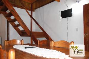 a wooden table with chairs and a wooden staircase at El Pindo Iguazu in Puerto Iguazú