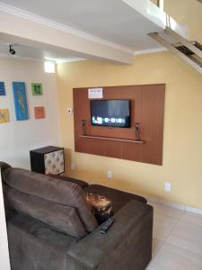 a living room with a couch and a flat screen tv at Loft em Botucatu prox unesp rubiao jr in Botucatu