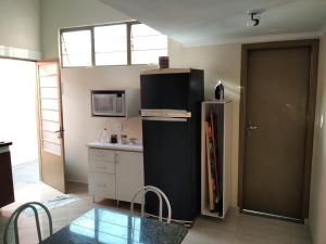a kitchen with a black refrigerator and a sink at Loft em Botucatu prox unesp rubiao jr in Botucatu +8 photos