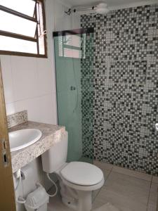 a bathroom with a toilet and a sink and a shower at Loft em Botucatu prox unesp rubiao jr in Botucatu