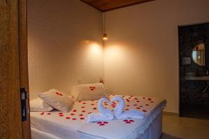 a bed with two swans made out of hearts at Pousada Vila Catarina in Ouro Preto
