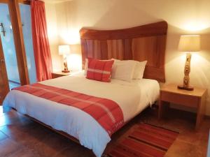 una camera con un grande letto con testiera in legno di Casa Tsaya Hotel Boutique a Bernal