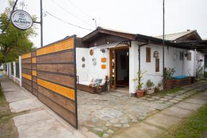 una pequeña casa con una puerta de madera delante de ella en Hostal del Mimbre Chile, en Santa Cruz