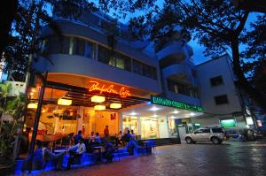 a group of people sitting outside of a restaurant at night at Bamboo Green Riverside Hotel in Danang