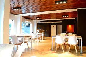 a dining room with white tables and white chairs at Hotel Terrazas by CPH in Villa Carlos Paz