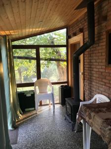 a room with a fireplace and a chair and a window at маленькое шале в с.Строенцы in Stroieşti
