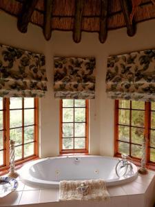 a large bath tub in a room with windows at Otters Den in Nottingham Road