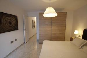 a bedroom with a large bed and a light at Apartamento Yale in Tías