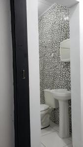 une salle de bain avec des toilettes blanches et un lavabo dans l'établissement Apto Térreo em Tramandaí, à Tramandaí