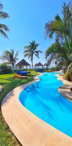 un complejo con una piscina con palmeras en el fondo en Bungalows Las Brisas Acapulco, en Acapulco