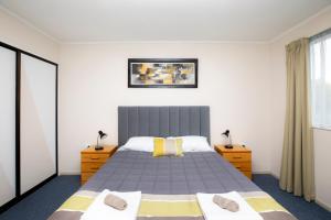 1 dormitorio con 1 cama grande y 2 mesitas de noche en Fitzgerald on King, en Timaru