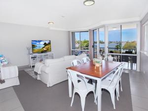 a living room with a white couch and a table and chairs at Broadwater Quays 5 in Mooloolaba