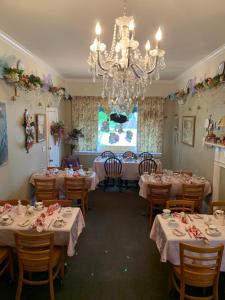 a dining room with tables and a chandelier at Emerald Necklace Inn Bed and Breakfast in Lakewood