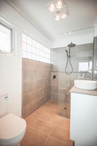 a bathroom with a shower and a toilet and a sink at Bayview no 1 in Port Campbell