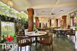 a restaurant with tables and chairs in a room at Taman Harum Cottages in Ubud