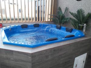 Del Valle House في إِكا: حوض استحمام ساخن أزرق في غرفة مع نافذة