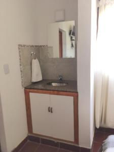 a bathroom with a sink and a mirror at Posada La Sofia in Tafí del Valle