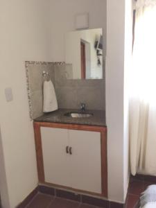 W łazience znajduje się umywalka i lustro. w obiekcie Posada La Sofia w mieście Tafí del Valle