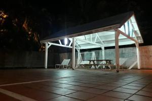 - un pavillon avec des chaises et une table de pique-nique la nuit dans l'établissement La Martinique vous tend les bras !, au Diamant 2 autres photos