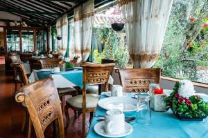 una sala da pranzo con tavoli e sedie e una finestra di Hotel Bahía Olivo Boutique & Spa a Villa de Leyva