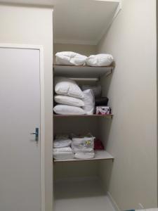 um armário cheio de toalhas e uma pilha de toalhas em Flor de Peroba Flats #2 Azul - Maragogi - AL em Maragogi
